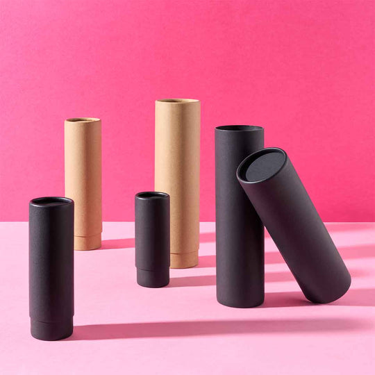 Collection of telescopic cardboard tubes in black and brown on a pink background. 