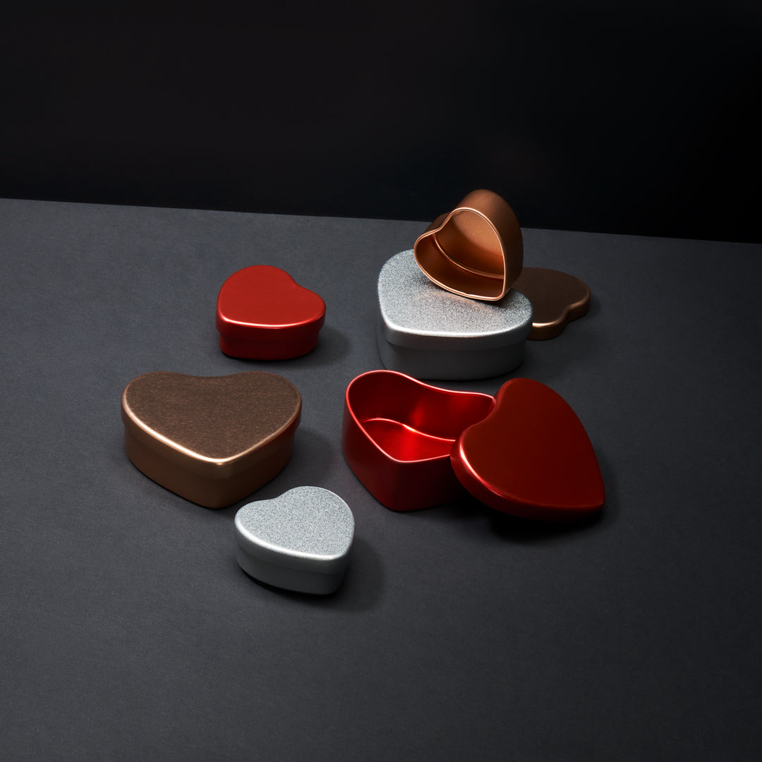 A collection of heart shaped tins in red, silver and rose gold.