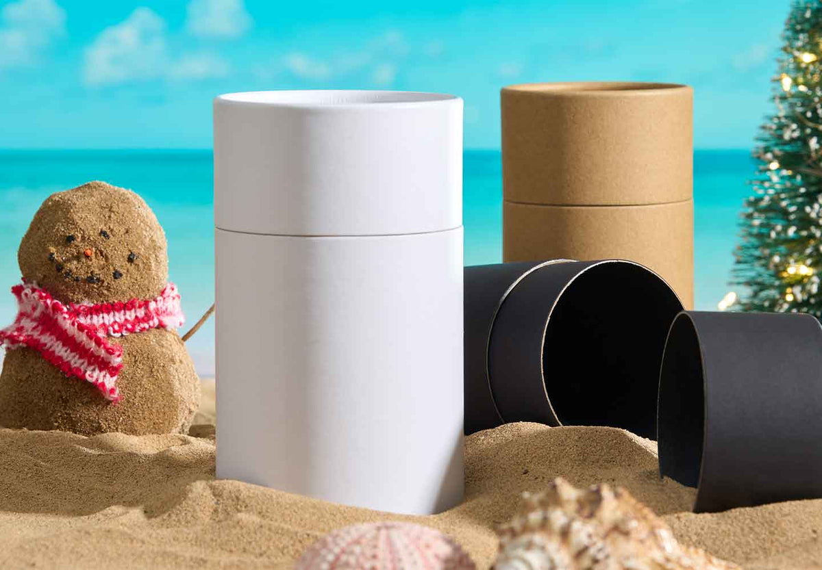 Cardboard tube packaging on beach with Christmas decorations